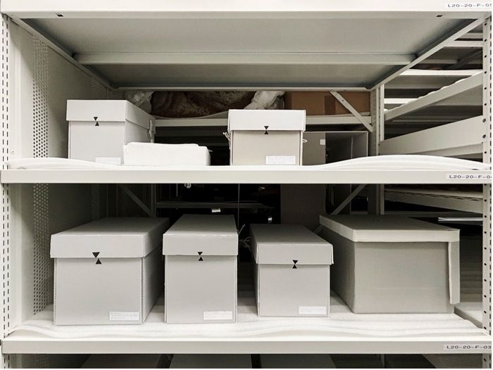 Ancestral remains respectfully housed in grey storage boxes in the museum’s collections. Restes ancestraux conservés avec respect dans des boîtes de conditionnement, dans les réserves du musée.