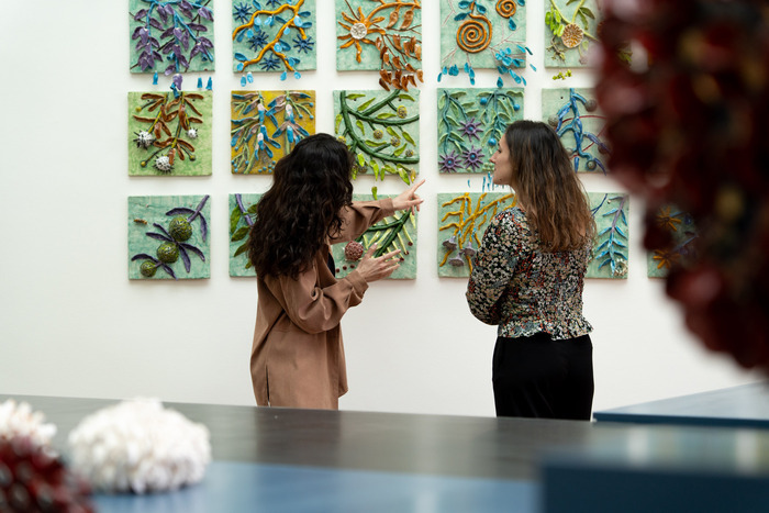 © Aloïs Rigotti, Musée Ariana Une médiatrice donne des informations à une visiteuse sur une installation murale d'azulejos très colorés.