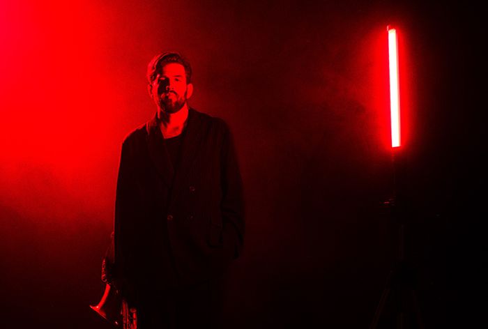 Une photo d'Arthur Donnot illuminé par une lumière rouge.