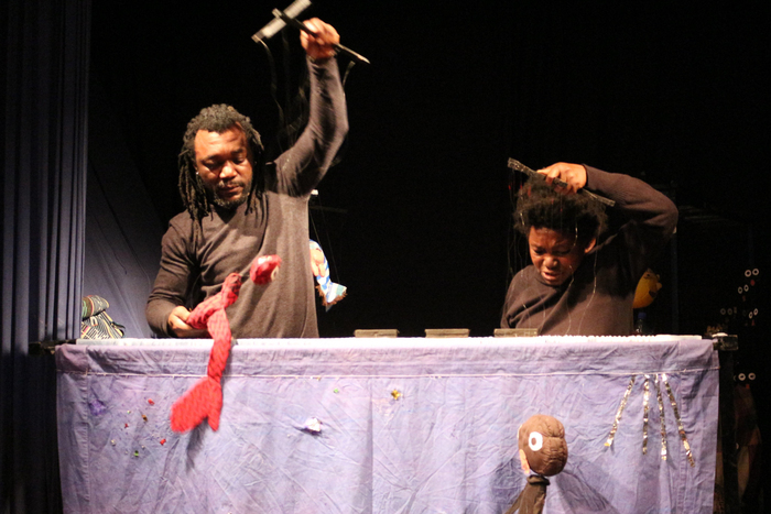 Un photo en couleur qui représente Fidèle Baha et Hyacinthe Brika tenant des marionnettes qu'ils ont créées.