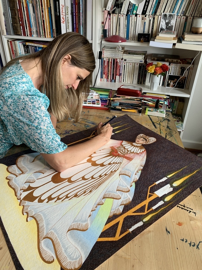Caroline Tscghumi dessinant à sa table de travail