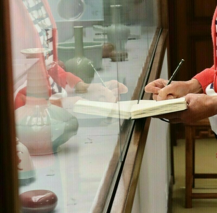 Fondation Baur Main en train de dessiner un croquis devant une vitrine du musée Baur