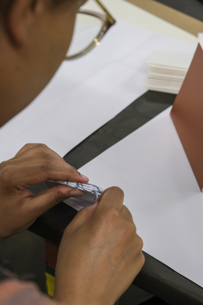 Photographie en gros de mains en train de relier un livre
