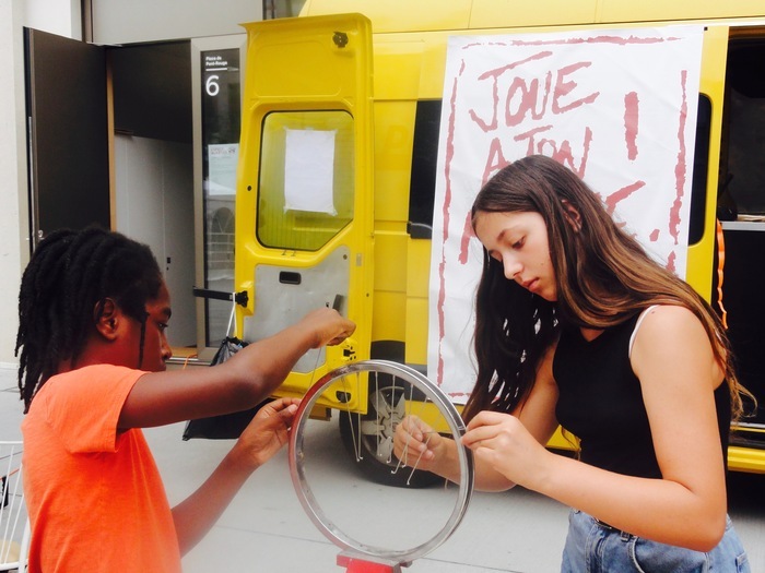 enfants qui fabriquent un instrument à partir d'une roue de vélo