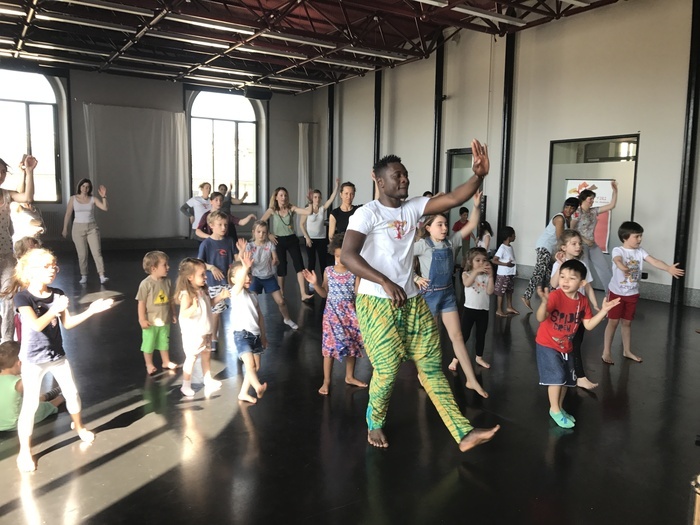 groupe d'enfants et d'adultes qui dansent lors d'un atelier
