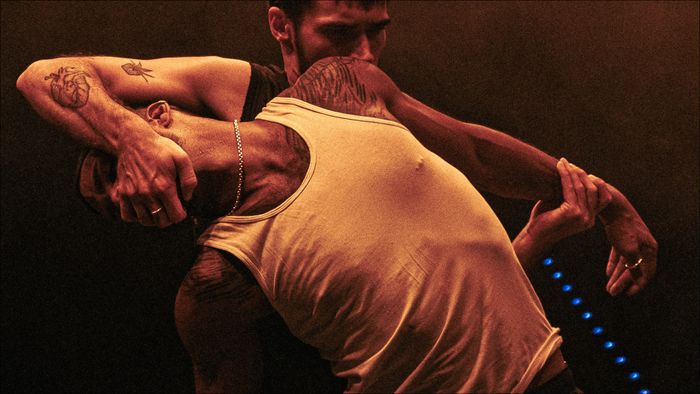 Deux hommes danses, l'un tient le visage de l'autre.