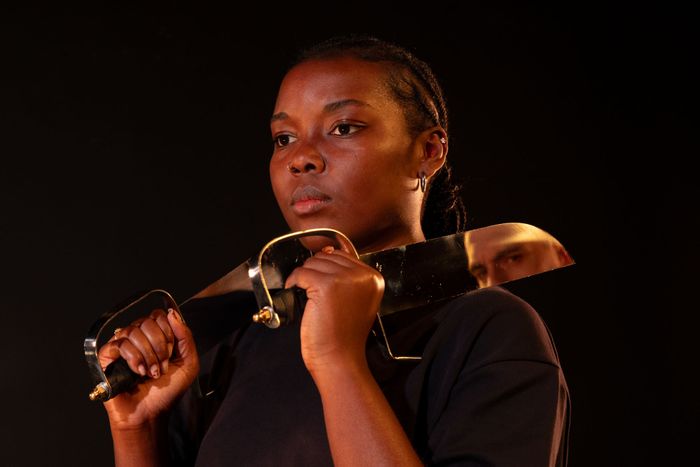 Portrait d'une femme tenant deux sabres posés sur ses épaules.