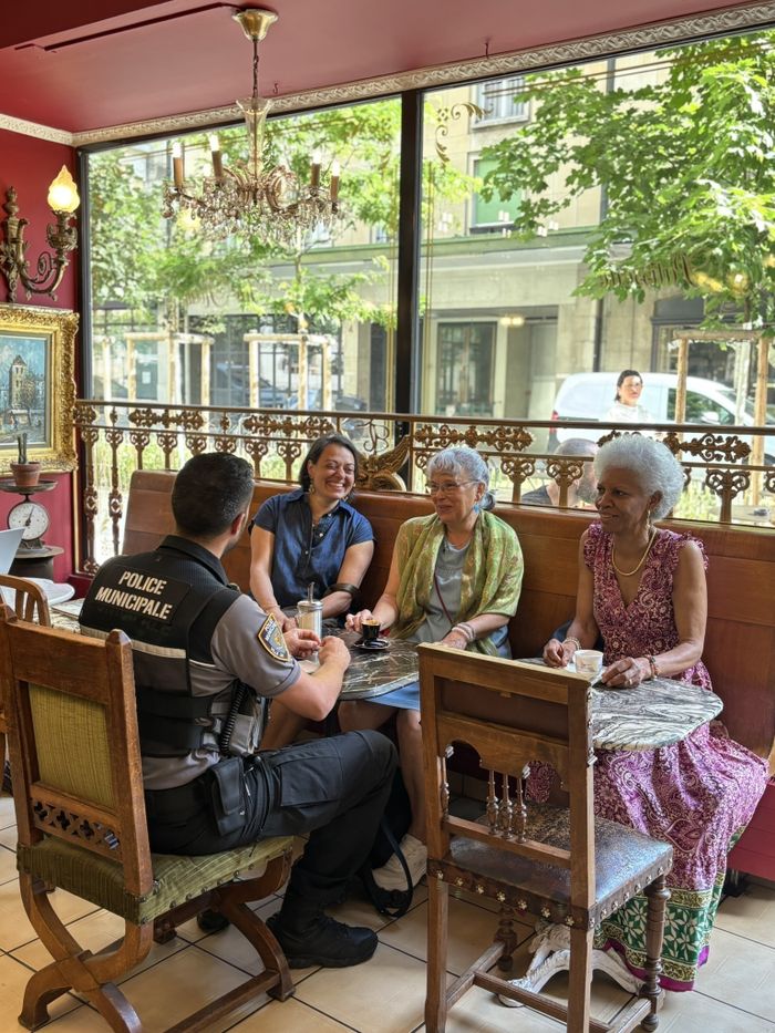 Un agent de la police municipale qui échange avec la population dans un café genevois