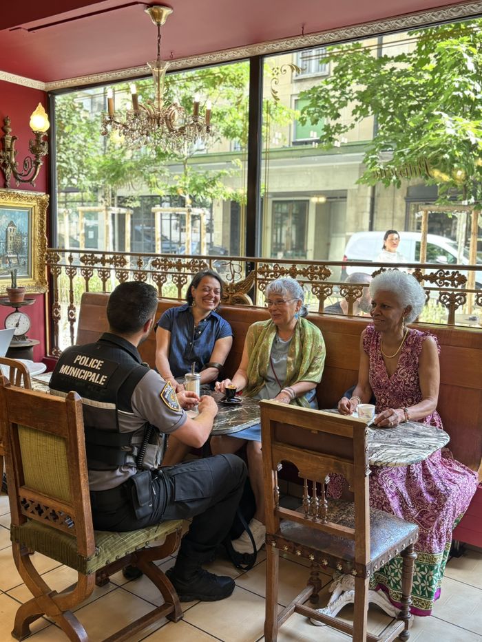 Un agent de la police municipale qui échange avec la population dans un café genevois