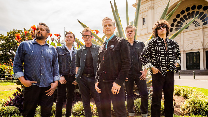 Les membres de Calexico posent avec les autres musiciens du groupe