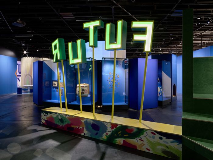 Vue de l'exposition avec les lettre FUTUR en verte sur des tiges. On voit une partie de l'exposition sur le thème des dialogues avec le futur.