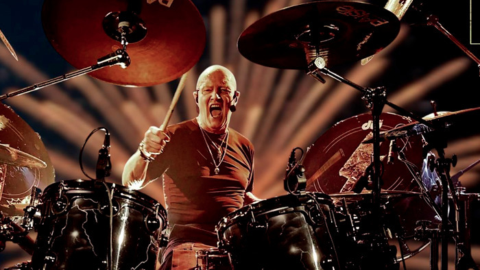 Photo de Chris Slade en train de jouer de la batterie en concert