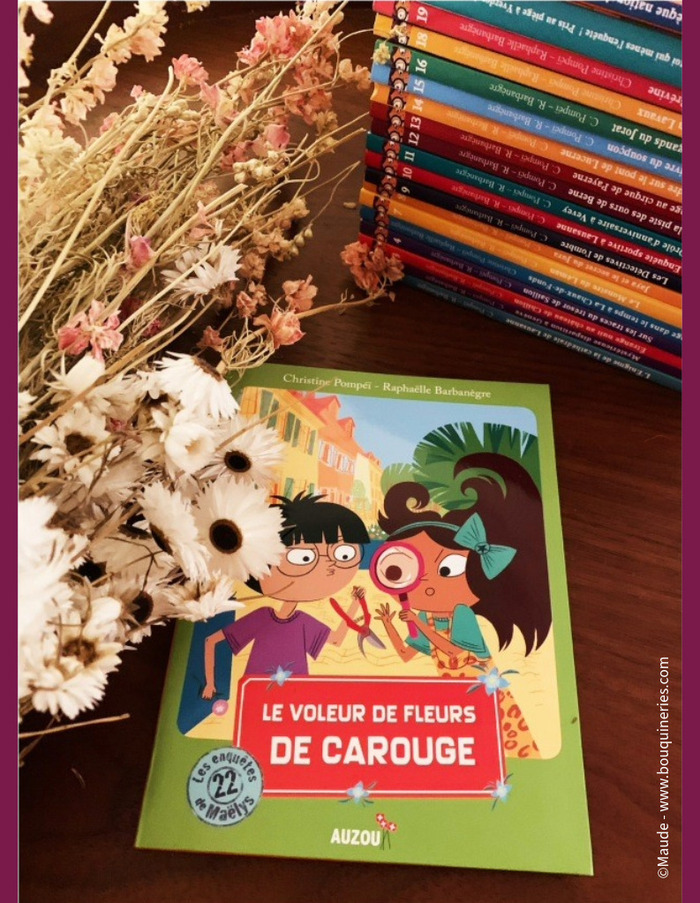 @Maude-www.bouquineries.com Image en couleur du livre "Le voleur de fleurs de Carouge", de la série "Les enquêtes de Maëlys", avec sur la couverture une petite fille et un petit garçon.
