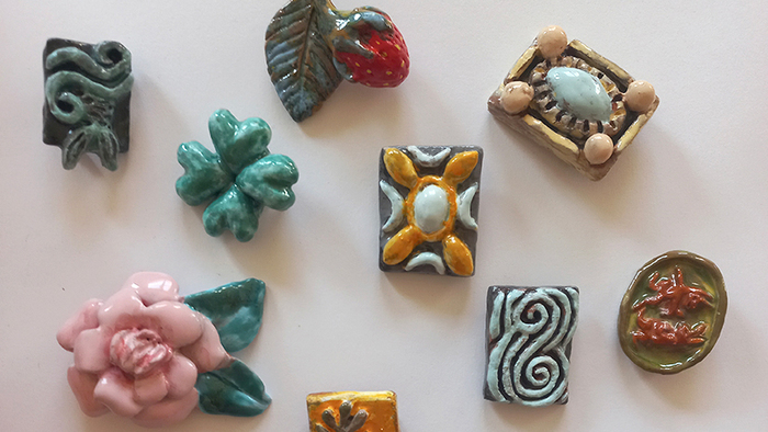 Broches en céramique réalisées par Marie Ducaté. Elles ont la forme de fleur, de feuille ou encore de fraise.