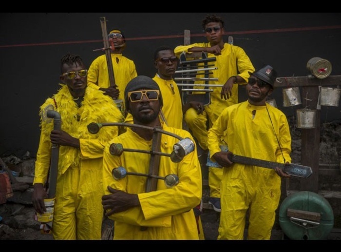 Système K Image du film avec 6 personnes qui posent avec leurs instruments de musique faits en matériel de récupération.