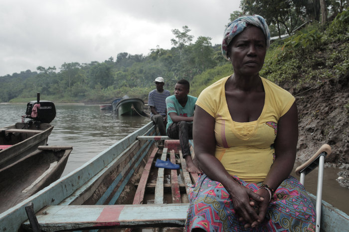 Femme au regard intense dans une pirogue sur le fleuve