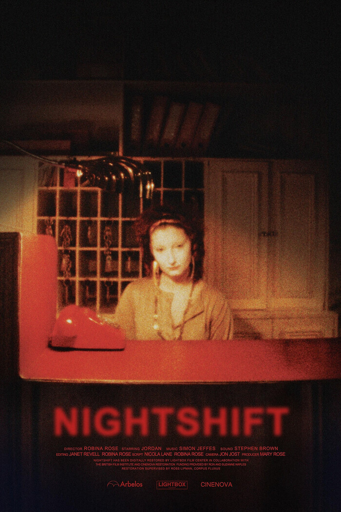 Affiche de film aux tons très sombres, dominée par des couleurs rouge foncé, brun et noir, avec une texture granuleuse des images de cinéma analogique. Au centre, une femme est assise derrière un comptoir d'hôtel rouge. Son visage est légèrement flou et éclairé par une lumière chaude qui crée une atmosphère nocturne et mystérieuse. Une lampe de bureau au design arrondi est posée à gauche, projetant une lumière tamisée. À l’arrière-plan, on distingue des étagères où des clés sont accrochées dans…