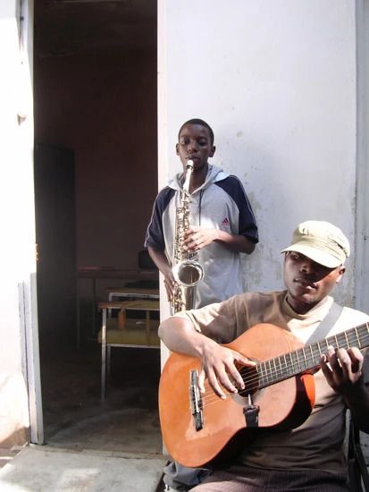 Un guitariste et au 2ème plan un joueur de saxophone