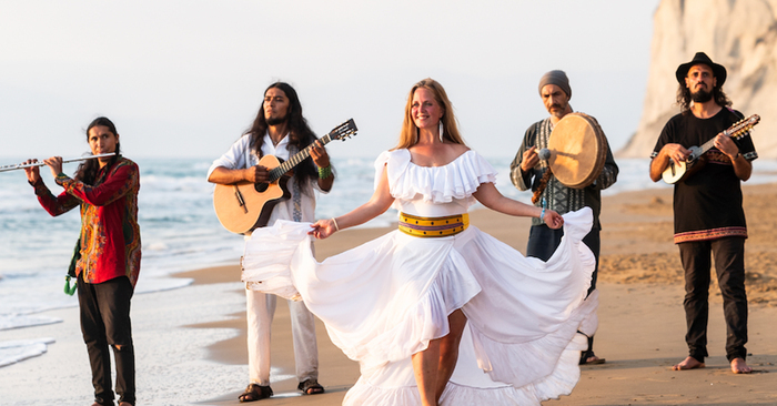 DR Les membres du groupe marche sur une plage en jouant de leurs instruments
