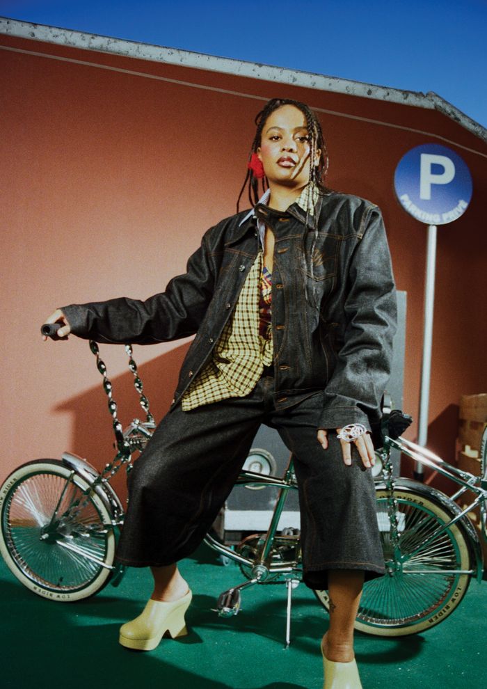 Portrait de plain-pied de Danitsa, adossée à une bicyclette vintage.