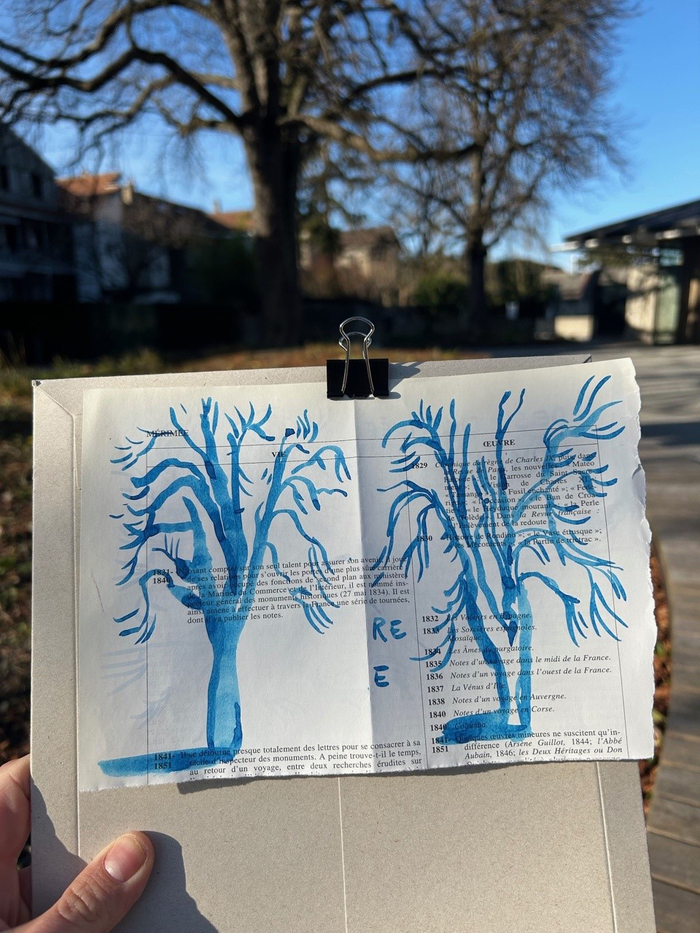 Anouck Fontaine Une photo en couleur qui représente un carnet de croquis sur lequel un arbre est dessiné à l'encre bleue.