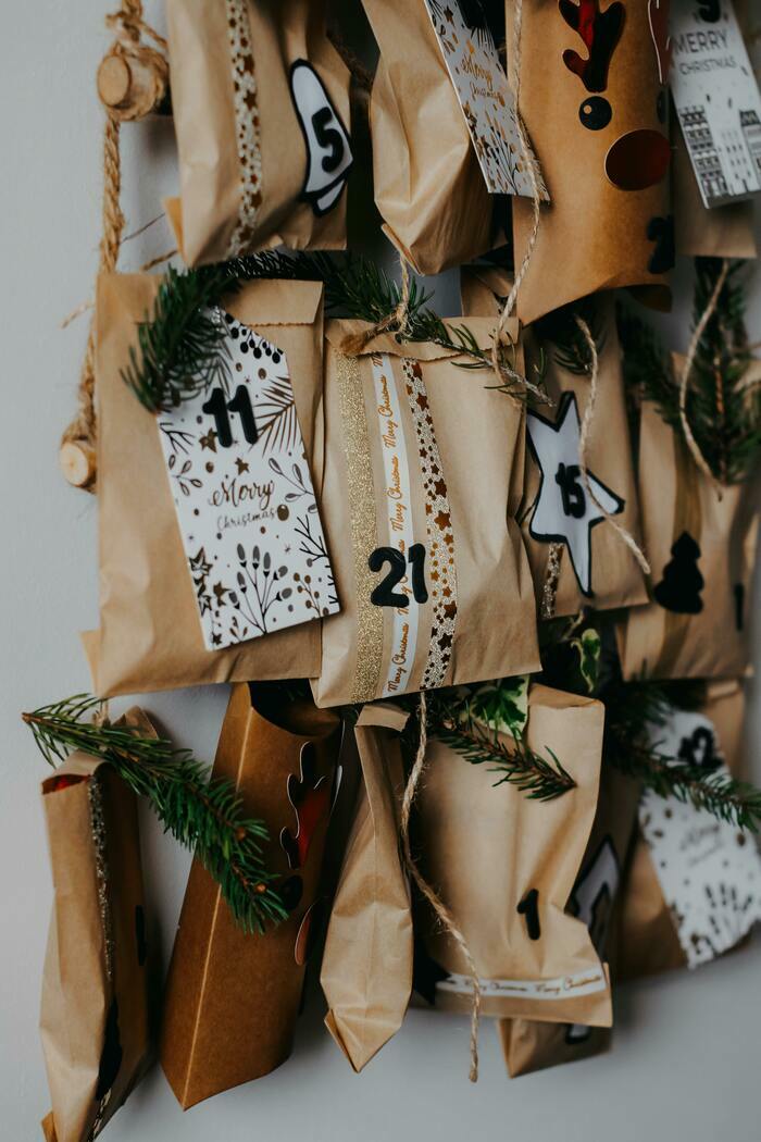 Paquets cadeaux en papier suspendus à une guirlande de fil et de branches de pin