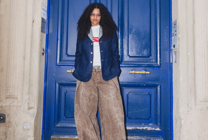 L'artiste Blue Mush debout devant une porte bleue flamboyante