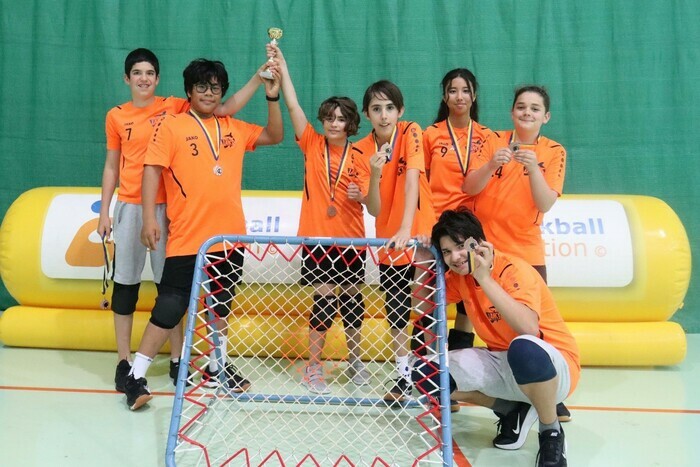 DR Equipe du Tchoukball Club de Lancy autour d'un cadre de Tchoukball, ils ont gagné une coupe et médailles.