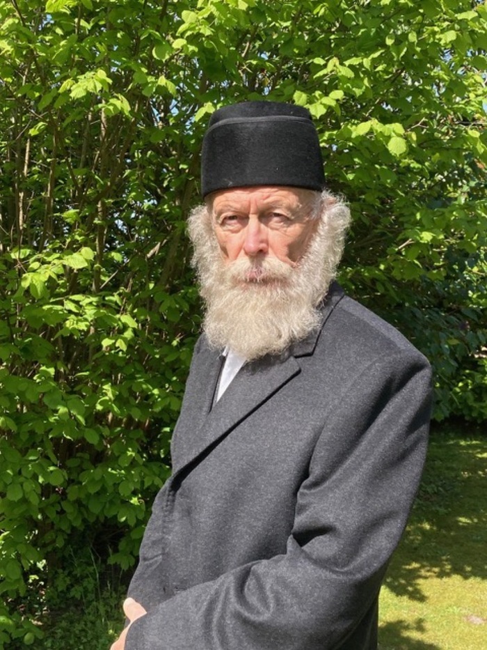 Un vieil homme barbu attentif dans un jardin