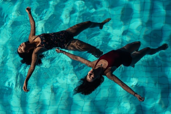Deux jeunes filles flottent dans une piscine.