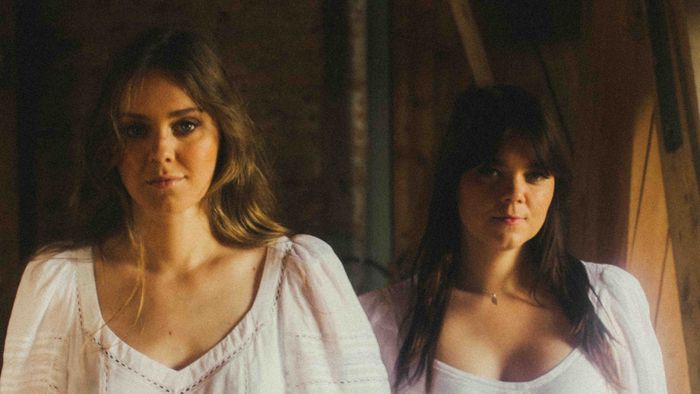 Portait des deux soeurs (Klara et Johanna Söderberg) qui forment First Aid Kit, habillées de robes blanches