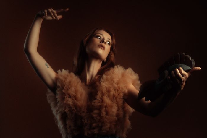 Photo de Grace Cummings, mise en scène artistique avec une pose sculpturale, rappelant un tableau clair-obscur.