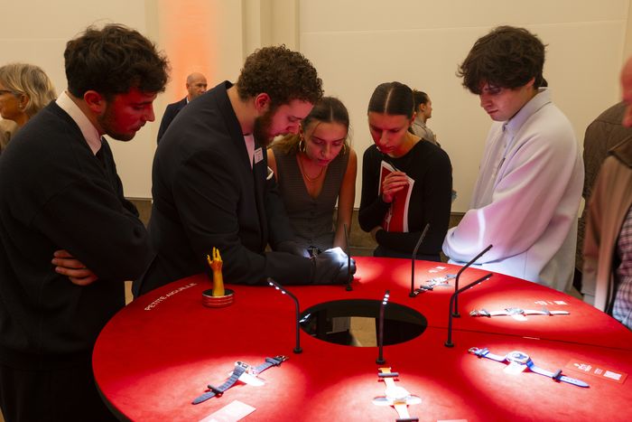 Public observant des montres dans une salle du musée