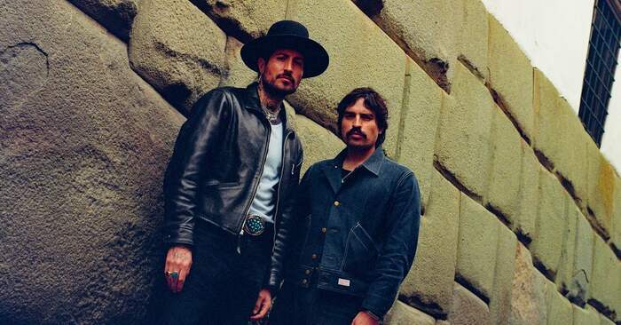 Les deux membres du groupe posent devant un mur