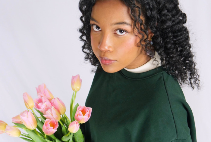Une photo de l'artiste tenant un bouquet de tulipes