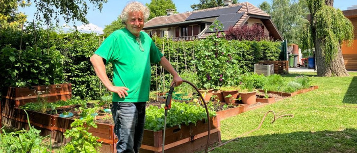 Steven, membre de La Ferme du Fond de l’Etang, devant le potager de La julienne