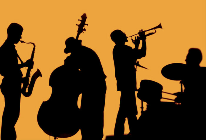 Silhouettes noires de musiciens sur fond orange