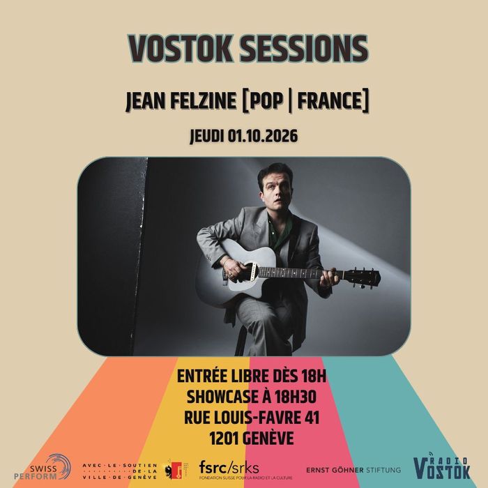L'artiste sur un fond gris en studio avec une guitare à la main.