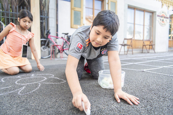 Enfants dessinant à la craie par terre
