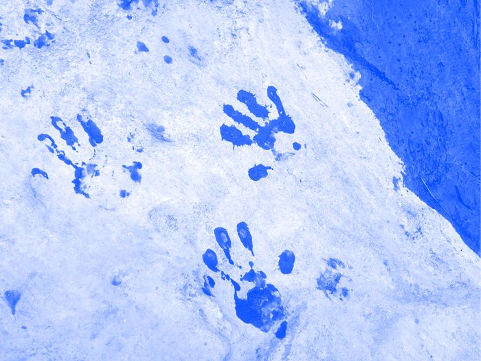 Des empreintes de mains sur une surface type sable ou neige. La photo a un filtre de couleur.