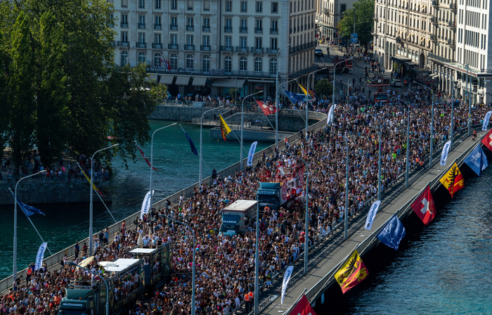 DR Sur cette image on peut voir une foule de personnes allant sur le pont du mont blanc à Genève. Au milieu de la foule on remarque des bus qui diffuse de la musique.