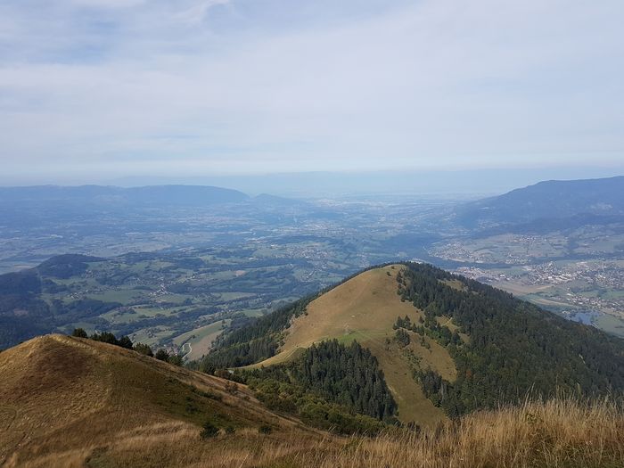 une photo en couleur prise depuis le sommet d'une montagne, vue sur la vallée.