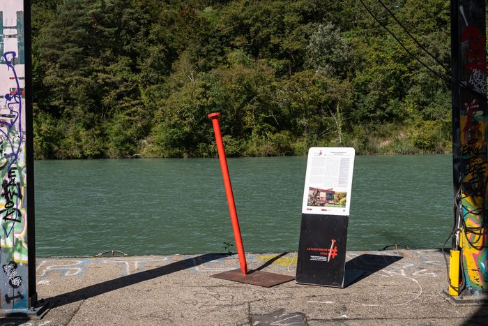Clou Rouge et panneau explicatif avec le Rhône en arrière-plan