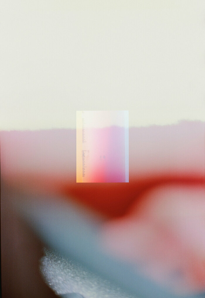 Photographie en couleur floue, montrant un paysage de montagne sur lequel est superposé, en transparence, une courte règle graduée.