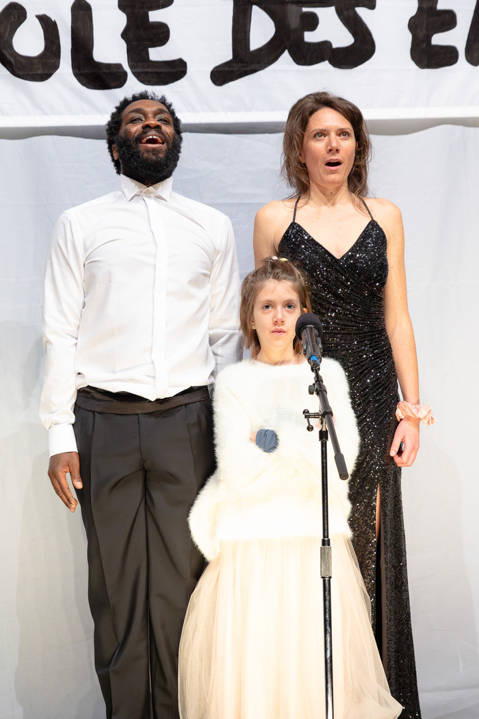 2 adultes et une enfant devant un micro
