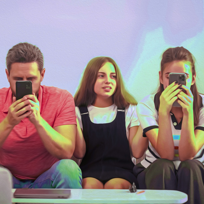 Trois personnes sur un canapé. Les deux adultes aux extrémités ont le nez rivé sur leur téléphone, l'ado au centre semble ne pas savoir quoi faire