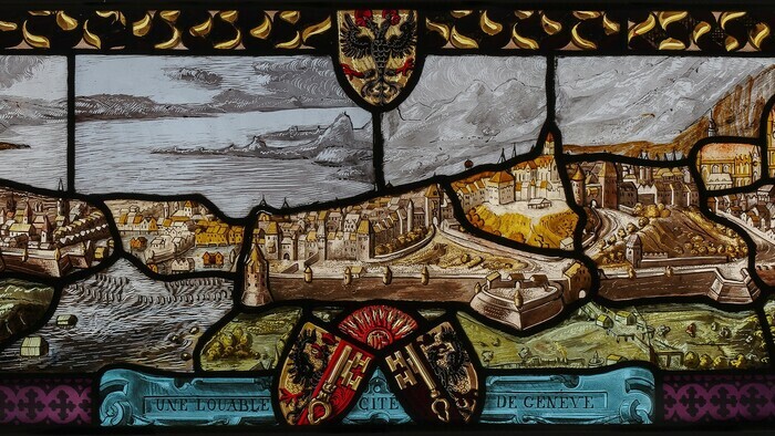 © Atelier Girardet Détail du « Vitrail de bienvenue aux armoiries de Genève, avec vue cavalière de la cité ». On y voit la cité de Genève.