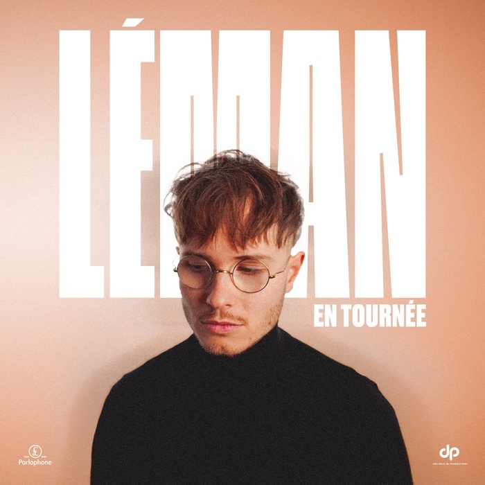 Affiche du concert de Léman. Portrait du chanteur de face, portant un pull noir et des lunettes rondes, regard baissé. Fond beige clair avec le prénom « LÉMAN » écrit en grandes lettres blanches derrière lui. Mention « En tournée » en bas à droite.