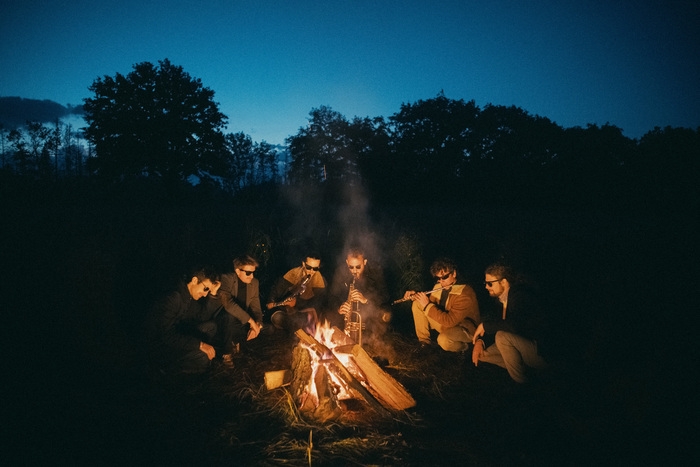 DR Les six musiciens autour d'un feu la nuit tombante