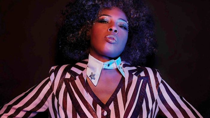 Portrait de Macy Gray habillée d'une blouse rayée brun et blanc